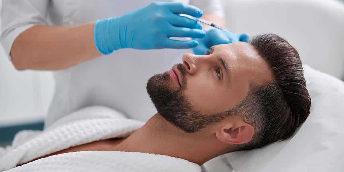 profissional de medicina estética aplicando colagénio na testa de homem - site Episense clínica de medicina estética facial e corporal em Matosinhos, Porto - Portugal
